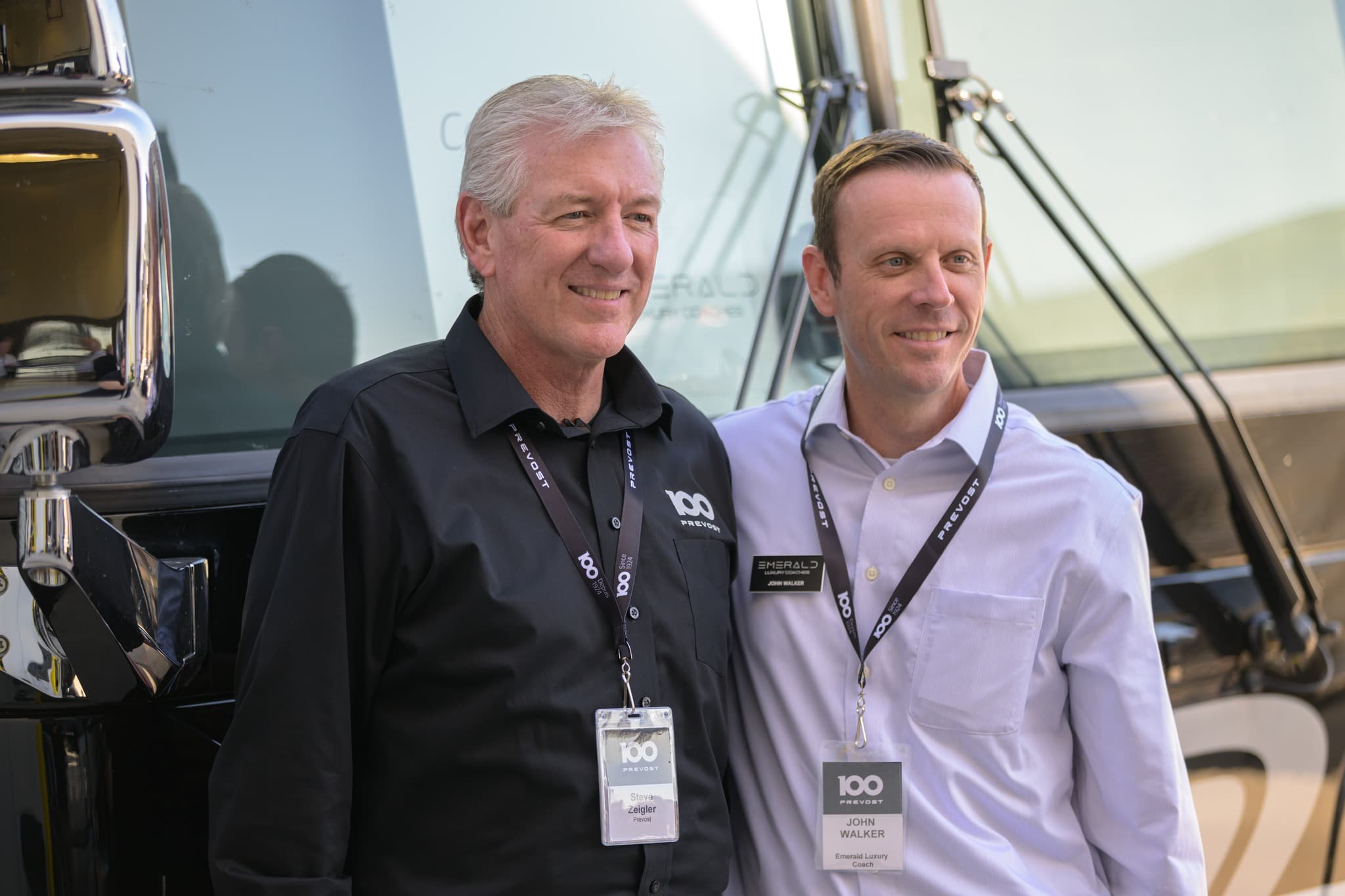 Steve Zeigler of Prevost and Emerald founder John Walker beside a coach at Prevost’s centennial celebration
